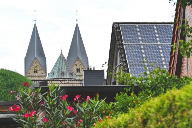 Solarförderung in Neuenkirchen: Zu sehen ist sind die Kirchtürme der Pfarrkirche St. Anna und eine PV-Anlage.
